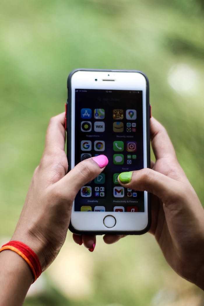 why-choose-us Close-up of a person holding a smartphone displaying various applications in Patna, India.
